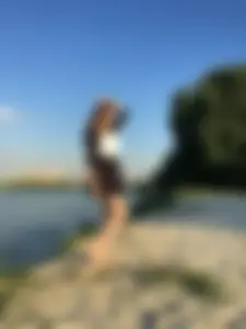 Barefoot Girl in a Skirt Standing on Sand By the Lake