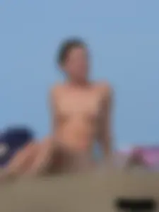Sexy babe with a nice body topless and in a thong on the beach
