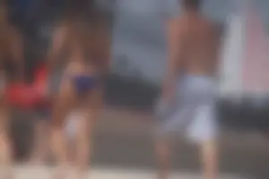 Two sexy friends, one blonde and one brunette, on the beach in bikinis