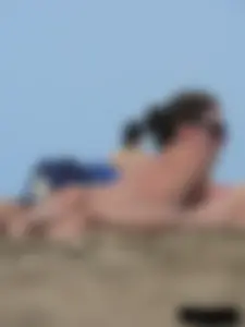 Sexy babe with a nice body topless and in a thong on the beach
