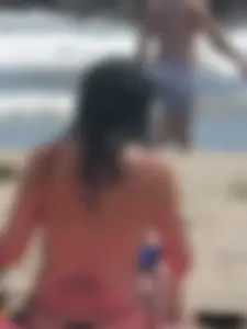 Brunette lady topless and in a black thong on the beach