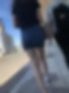 Cute Girl in a Short Denim Skirt Walking on a Street And Waiting on a Crosswalk Gallery