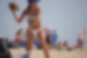 Beach football sexy brunette in white bikini