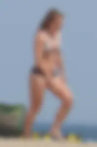 Sexy blonde girl on the beach in a bikini with nice legs, ass and stomach