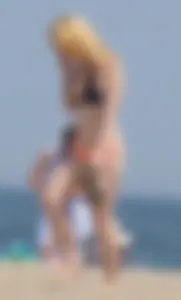 Hot blonde in peach and black bikini on the beach