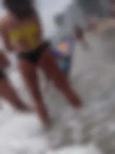 Beach babe in yellow and black bikini bending over