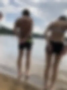 Girl With Thin Legs in Shorts and a Bra Afraid to Walk Into the Water