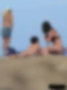 Sexy babe with a nice body topless and in a thong on the beach