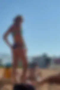 Sexy blonde milf on the beach in blue thong bikini and showing nice camel toe