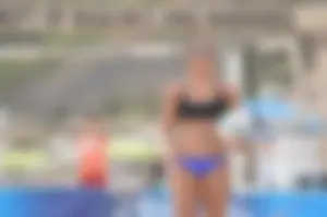 Sexy beach volleyball girl in sport bra top with pokies and blue bikini bottom