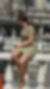 Chubby Girl in a Dress Sitting on the Embankment Banister Candid Photo