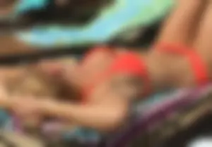 Sexy blonde lady in a bikini with a great body laying by the pool