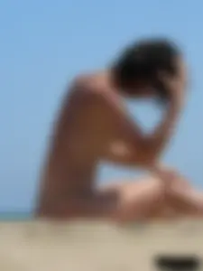 Topless beach milf looking sexy in a tiny g-string bikini