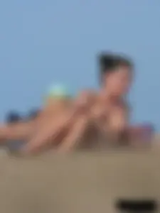 Sexy babe with a nice body topless and in a thong on the beach