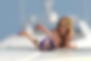 Avril Lavinge looking sexy in purple bikini on a boat