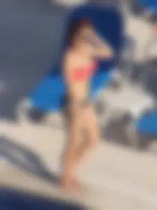 Sexy red haired girl in pink and black bikini at the pool
