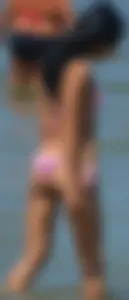 Little brunette ass in a pink bikini at the beach