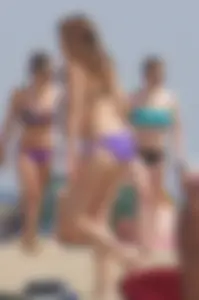 Cute girls in light blue and purple bikinis on the beach