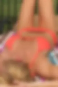Sexy blonde lady in a bikini with a great body laying by the pool