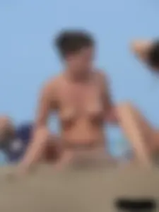 Sexy babe with a nice body topless and in a thong on the beach