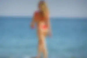 Hot blonde with a slammin body in red thong bikini on the beach