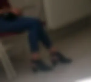 A Skinny Girl in Shoes With Heels And Tight Blue Jeans Sitting With Crossed Legs, Creepshot at the Public Library