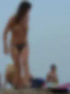 Sexy babe with a nice body topless and in a thong on the beach