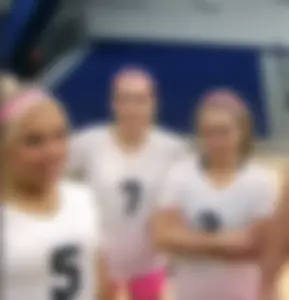 Bunch of cute college girls in bright pink shorts playing volleyball