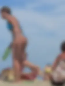 Sexy lady on the beach in a blue thong bikini