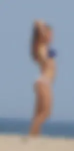 Redhead and brunette friends looking sexy in bikinis on the beach