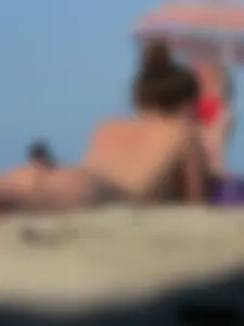 Sexy babe with a nice body topless and in a thong on the beach