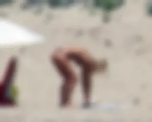 Small boobed topless milf on the beach