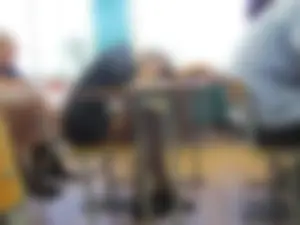 Bored College Girl in a Short Dress And Flats Lying On Desk And Playing With Her Shoe in a Classroom