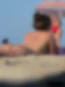 Sexy babe with a nice body topless and in a thong on the beach