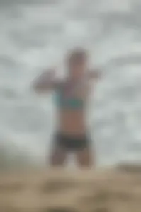 Blonde lady on the beach in bikini top and spandex shorts with a nice gap