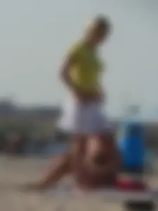 Blonde on the beach topless with big boobs and in a black thong