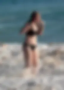 Cute bikini girl in the water in a black bikini