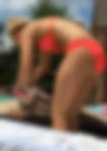 Sexy blonde lady in a bikini with a great body laying by the pool
