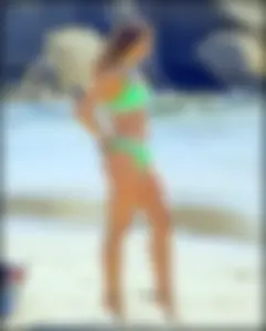 Super hot beach babe with a perfect body in a green thong bikini