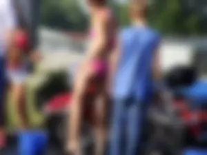 Group of cute girls at a car wash in bikinis and shorts