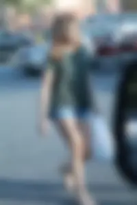 Cutie walking in the parking lot in jean shorts