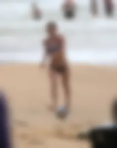 Hottie bikini babe on the beach kicking around a volleyball