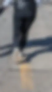 A beautiful little brunette walking in the park. tight black leggings