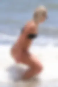 Beach blonde in the water in black bikini with a nice ass and small boobs