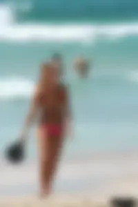 Topless girl in a tiny thong on the beach playing paddle ball
