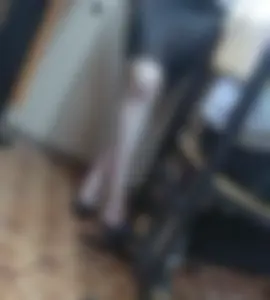 Crossed Legs of a College Girl Standing in a Skirt And High-Heeled Shoes