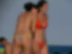 Topless beach babe with nice tits and ass in blue thong bikini