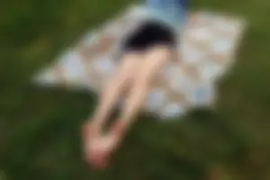 Barefoot Girl in a Skirt Lying on the Blanket on the Grass Candid Photo