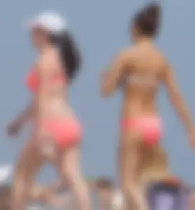 Two sexy girls in peach and pink bikinis on the beach