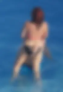 Sexy red haired girl in pink and black bikini at the pool